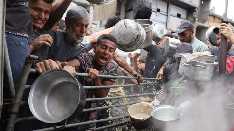 Families queuing at a food distribution point in Gaza
